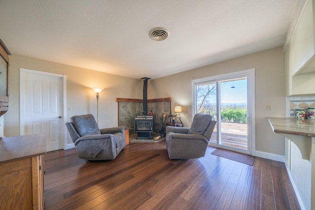 living room featuring a wood stove and dark hardwood / wood-style flooring