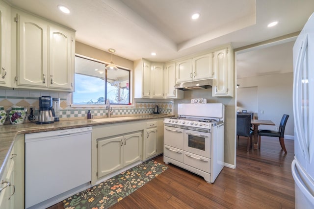 kitchen with sink, white appliances, white cabinets, dark hardwood / wood-style flooring, and decorative backsplash