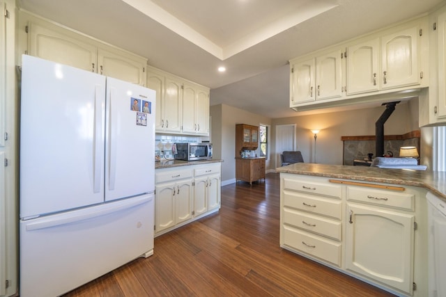 kitchen featuring tasteful backsplash, dark hardwood / wood-style flooring, white cabinets, and white appliances