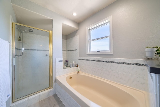 bathroom featuring separate shower and tub