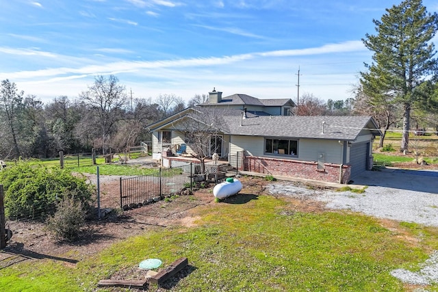 back of house featuring a yard and a garage