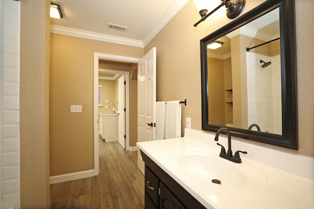 bathroom with vanity, hardwood / wood-style floors, crown molding, and walk in shower