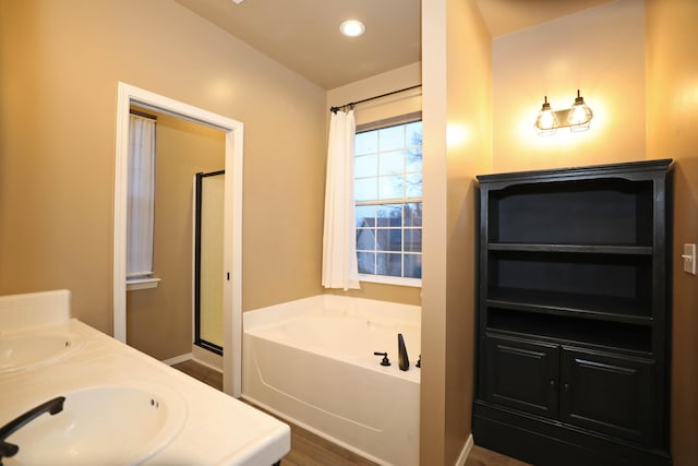 bathroom with vanity and shower with separate bathtub