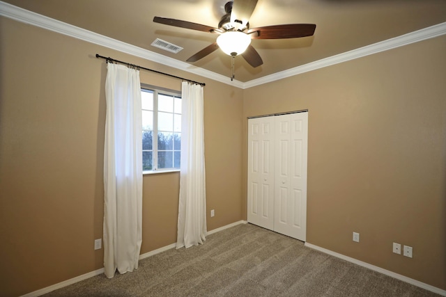 unfurnished bedroom with ceiling fan, ornamental molding, carpet floors, and a closet