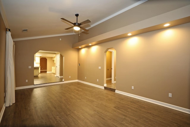 empty room featuring ceiling fan, ornamental molding, dark wood-type flooring, and vaulted ceiling