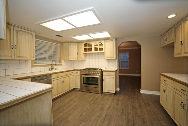 kitchen featuring tile counters, stainless steel appliances, dark hardwood / wood-style flooring, backsplash, and light brown cabinets