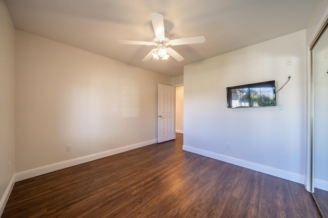 unfurnished room featuring ceiling fan, dark wood finished floors, and baseboards