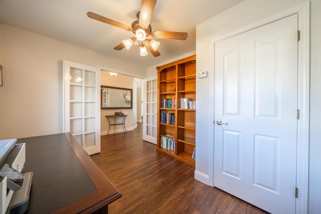 unfurnished office featuring baseboards, a ceiling fan, dark wood-style flooring, and french doors