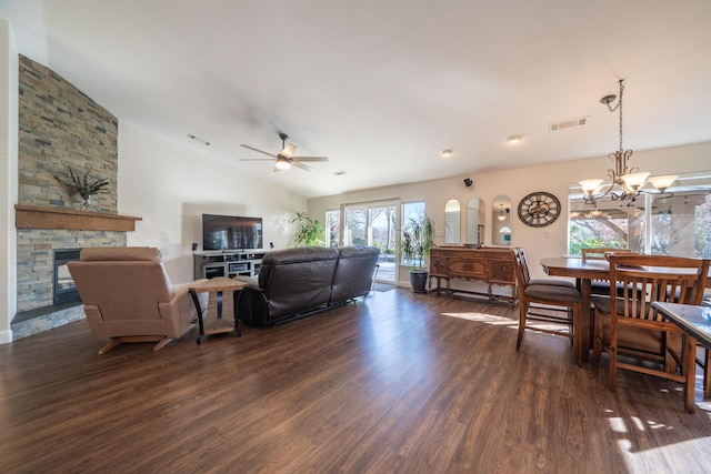 living room with vaulted ceiling, dark wood-type flooring, a fireplace, and visible vents