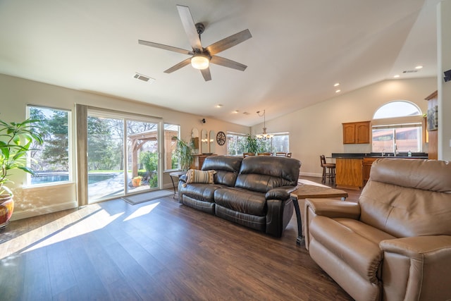 living room featuring lofted ceiling, plenty of natural light, visible vents, and dark wood-type flooring