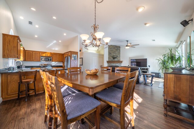 dining room with recessed lighting, dark wood-style flooring, a fireplace, visible vents, and vaulted ceiling