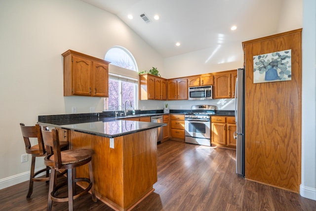 kitchen with brown cabinets, visible vents, stainless steel appliances, and a sink