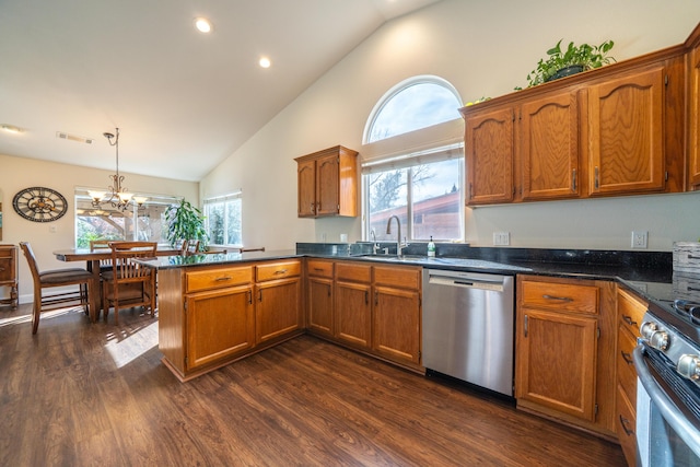 kitchen featuring dark wood-style floors, brown cabinets, stainless steel appliances, pendant lighting, and a sink