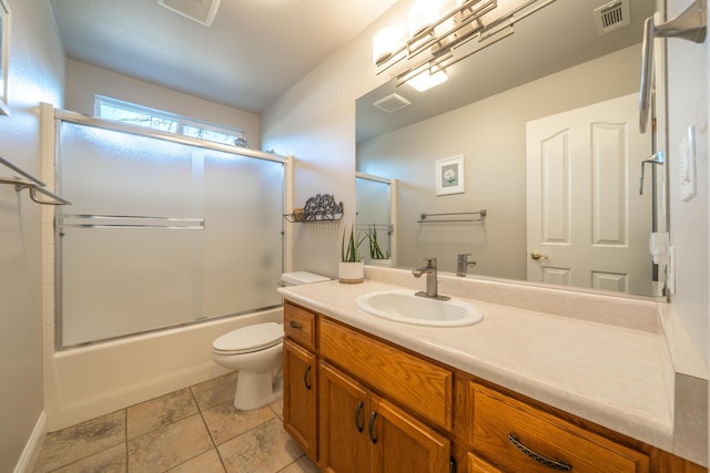 full bath featuring visible vents, toilet, vanity, and combined bath / shower with glass door