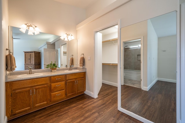 bathroom with double vanity, a sink, baseboards, and wood finished floors