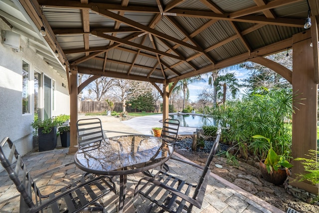 view of patio / terrace with a gazebo, outdoor dining area, and fence