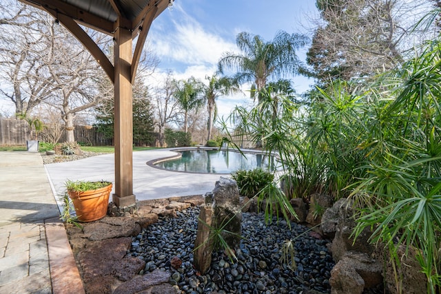 view of swimming pool featuring fence, a fenced in pool, and a patio