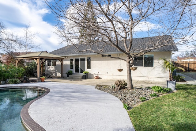 exterior space featuring a patio, stucco siding, a gazebo, fence, and driveway