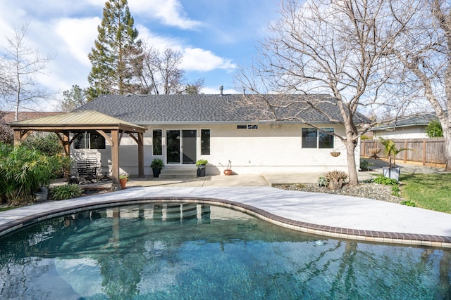 back of house with entry steps, fence, a gazebo, stucco siding, and a patio area