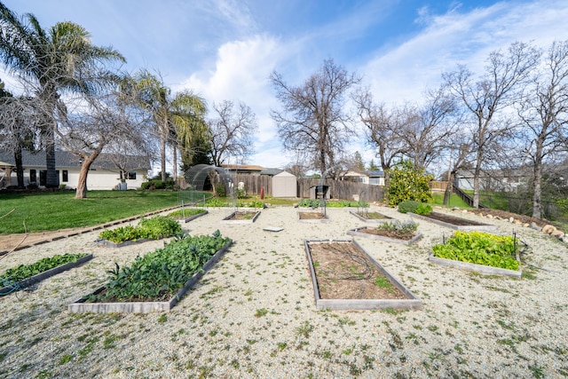 view of yard with a shed, fence, a vegetable garden, and an outdoor structure