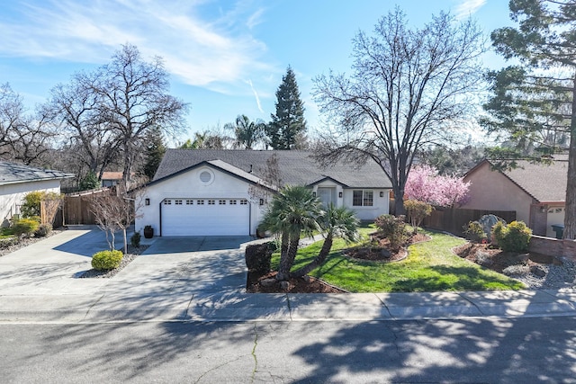 view of front of house with an attached garage, fence, concrete driveway, stucco siding, and a front yard