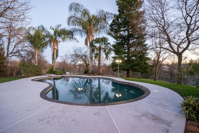 outdoor pool featuring a patio and fence