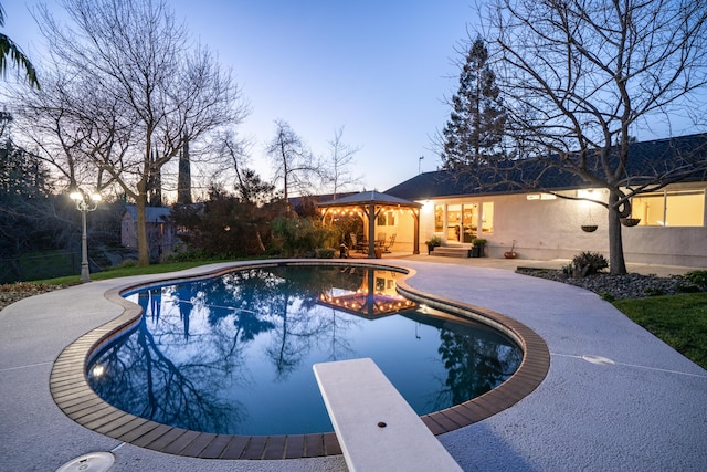 view of swimming pool with a fenced in pool, a diving board, a patio, and fence