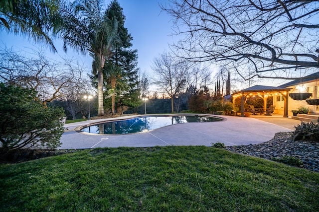 outdoor pool with a patio area, a lawn, and a gazebo