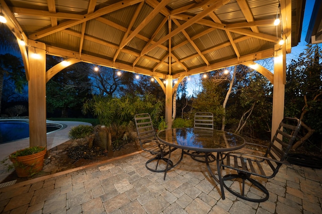 view of patio with outdoor dining space, an outdoor pool, and a gazebo