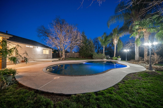 pool at twilight featuring a patio area, fence, and a fenced in pool