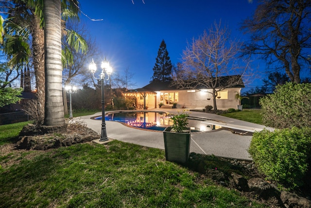 pool featuring a patio, a lawn, and fence