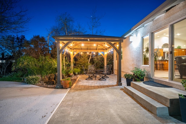 patio at twilight featuring a gazebo