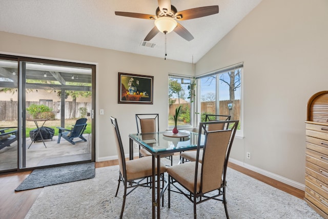 dining room featuring ceiling fan, lofted ceiling, hardwood / wood-style floors, and a wealth of natural light