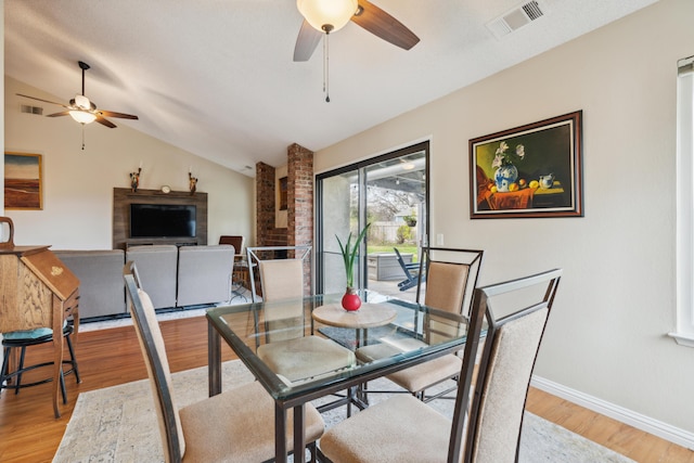 dining space featuring ceiling fan, lofted ceiling, and light hardwood / wood-style flooring