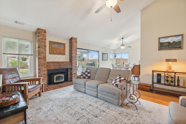 living room featuring ceiling fan, lofted ceiling, a wealth of natural light, and light hardwood / wood-style floors