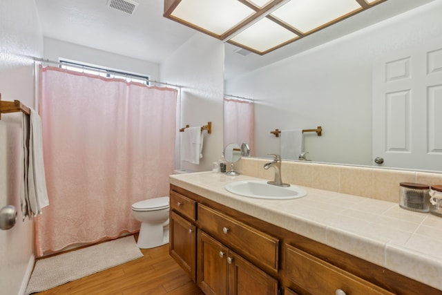 bathroom with wood-type flooring, vanity, and toilet