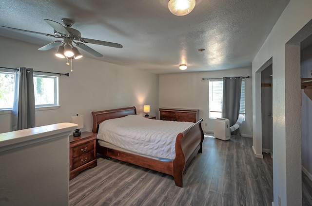 bedroom with ceiling fan, dark wood-type flooring, and a textured ceiling