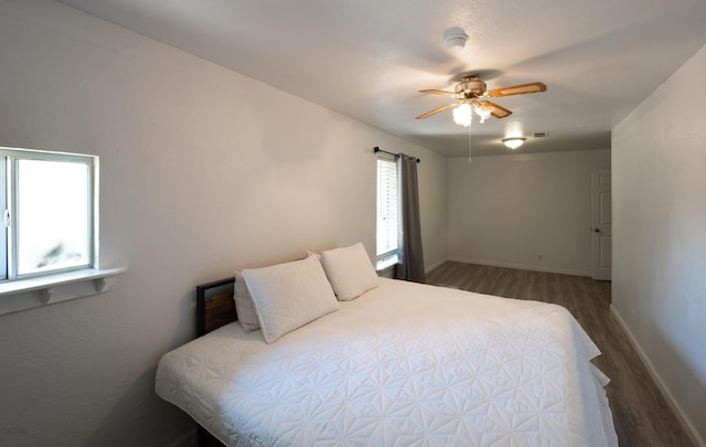 bedroom with dark hardwood / wood-style floors and ceiling fan