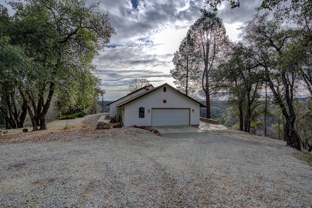 view of property exterior featuring driveway, an attached garage, and stucco siding