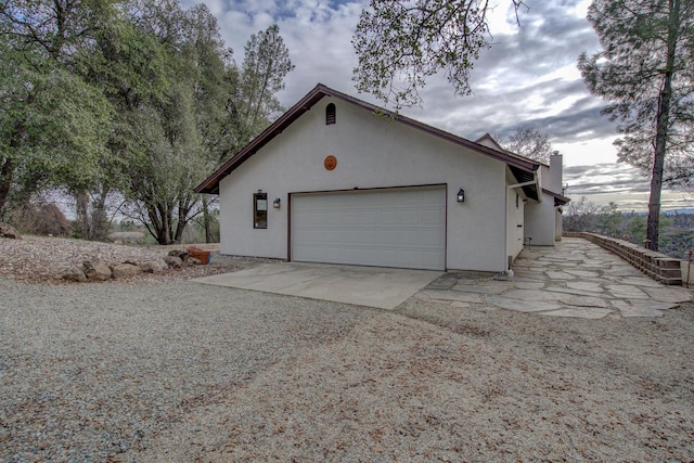 view of home's exterior featuring a garage, driveway, and stucco siding