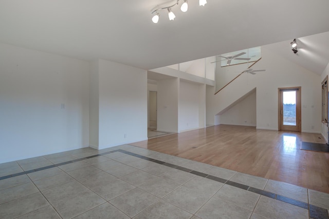 spare room featuring ceiling fan, high vaulted ceiling, and light tile patterned flooring