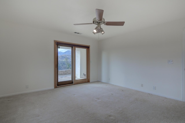 empty room featuring baseboards, visible vents, a ceiling fan, and light colored carpet