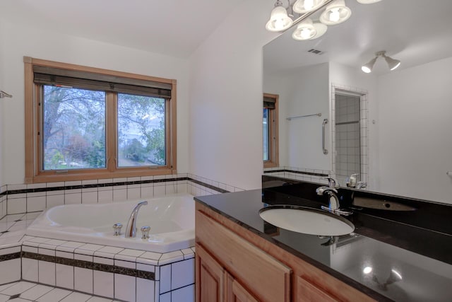 full bath featuring a relaxing tiled tub, vanity, and visible vents