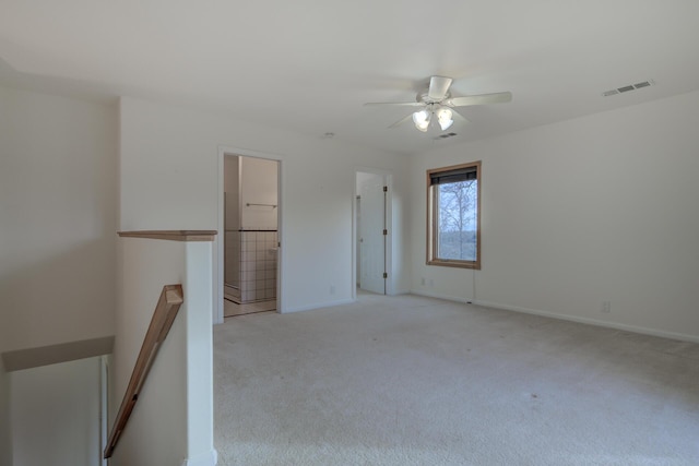 spare room featuring baseboards, visible vents, a ceiling fan, and light colored carpet