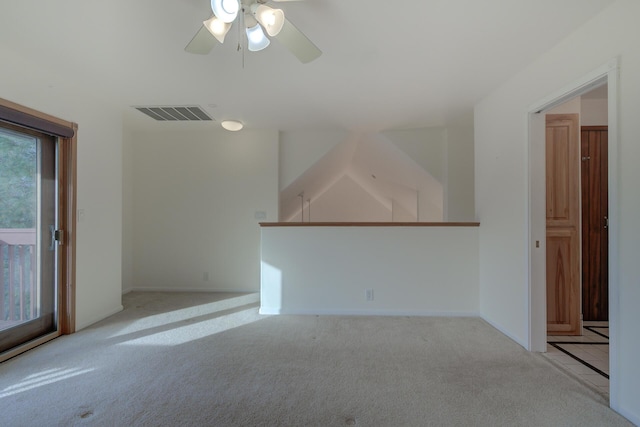 empty room featuring visible vents, a ceiling fan, and light colored carpet