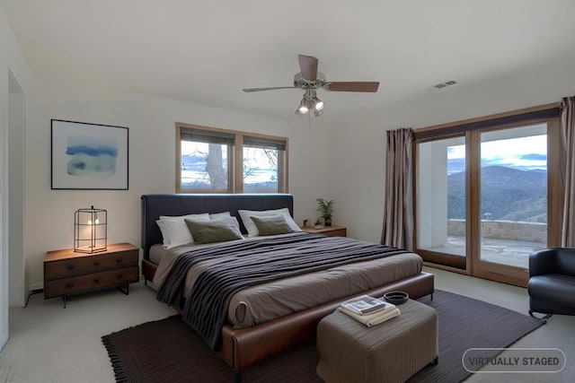 bedroom featuring carpet floors, access to exterior, visible vents, and a mountain view