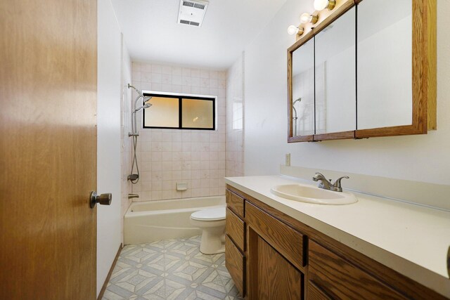 full bathroom with vanity, tiled shower / bath combo, and toilet