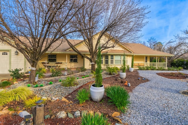 single story home featuring a porch, a tile roof, and stucco siding