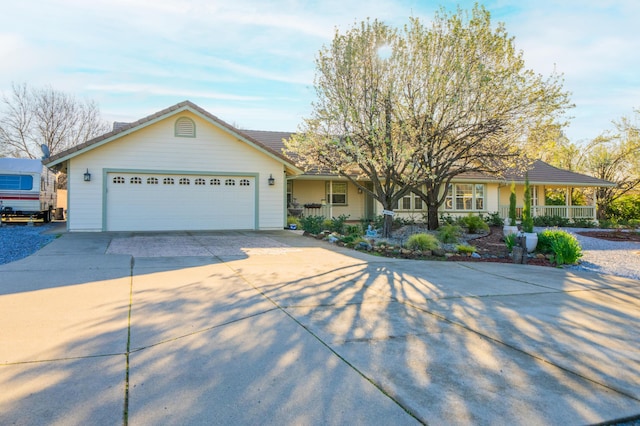 ranch-style house with a porch, driveway, and a garage