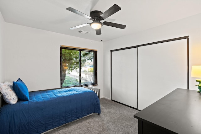 carpeted bedroom featuring ceiling fan and a closet